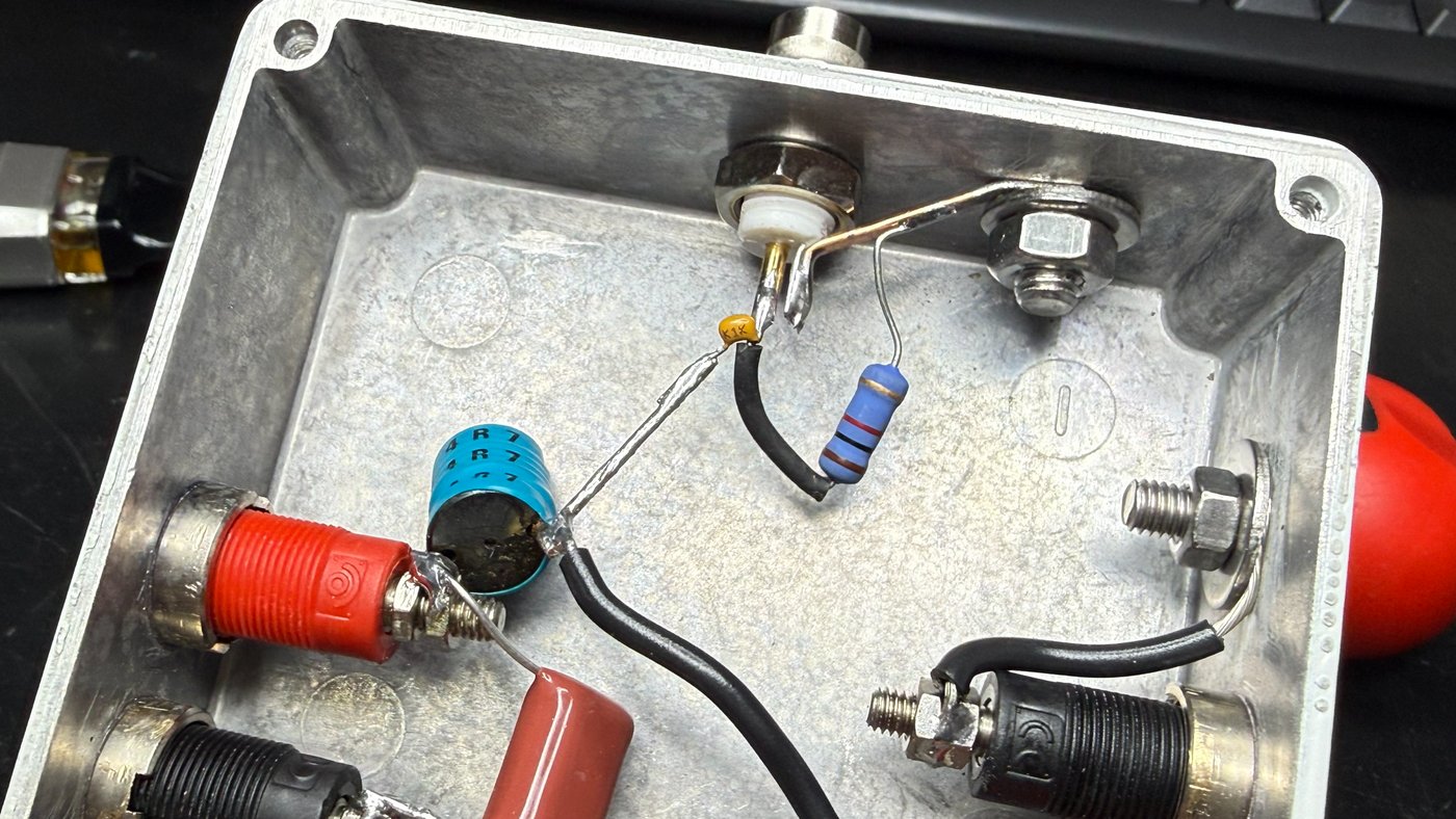 The measurement node up close: 100 nF into the BNC centre pin, 1 kΩ bleeder, and the flat copper strip from the BNC shell
